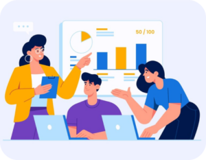two women pointing at a chart above a man with two laptops in front of them.